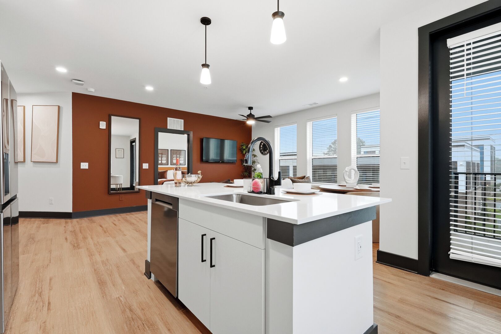 A modern kitchen with a central island, built-in appliances, and large windows.