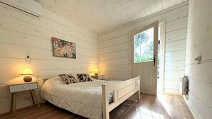 Une chambre à coucher avec un lit, des lampes de chevet, une fenêtre et une porte.