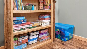 Une bibliothèque contenant divers jeux de société et casse-têtes.