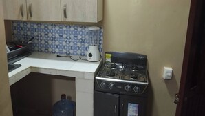 A kitchen with a stove, a blender, and a water dispenser.