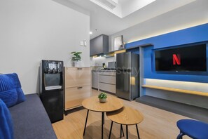 Eine moderne Küche mit Einbauofen, Kühlschrank und einem an der Wand befestigten Fernseher.