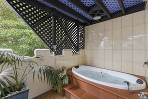 A bathroom with a large bathtub, tiled walls, and a lattice structure. - The Castle - Villa by the Sea (Cowes)
