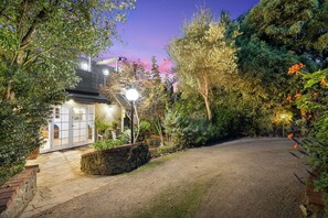 A residential property with a gravel driveway, stone walls, and a variety of plants and trees. - The Castle - Villa by the Sea (Cowes)