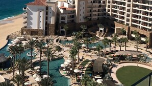Un complex turístic amb zona de piscina, platja i vista a l'oceà.
