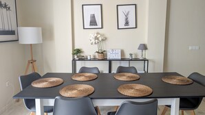 A dining area with a long table, six chairs, and woven placemats.