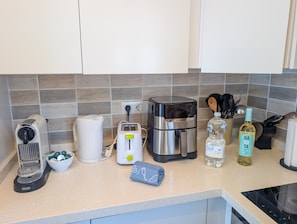 A kitchen counter with a coffee maker, toaster, kettle, and a bottle of water. - Calahonda 2BR Garden Apt · Pool · Beach Walk (Mijas)