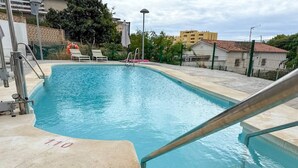 Une piscine avec une échelle en métal et une bouée de sauvetage.