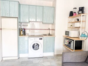 Eine kleine Küche mit Waschmaschine, Mikrowelle und Toaster.