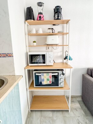 Eine Küche mit eingebauter Mikrowelle, Toaster und Kaffeemaschine auf einer Holzkonsolenwand.