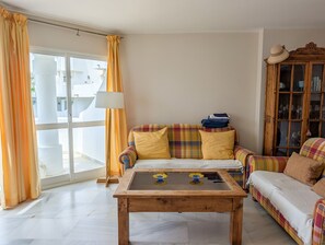 Ein Wohnzimmer mit einer Couch, einem Couchtisch und einer Vitrine.