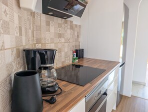 A kitchen with a coffee maker, a glass carafe, and a power outlet on the counter. - Pinos: Serene 2BD w/pool, views & walk to beach (Mijas)