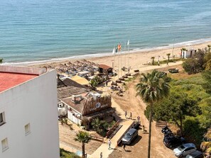 Ein Hotel an der Küste mit Blick auf den Strand, Außenbereich und Parkplatz.