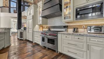 A kitchen with a large stove, oven, and microwave.