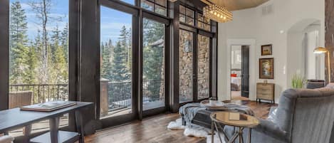 Un salón amplio con ventanas grandes, una chimenea y una zona de estar acogedora.