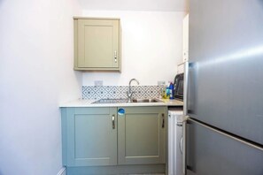 A compact kitchen with a sink, a microwave, and a refrigerator.