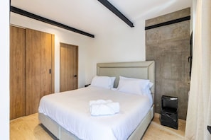 Ein Schlafzimmer mit einem Bett, einem Kleiderschrank und einem Mülleimer.