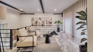 Een moderne woonkamer met een bank, salontafel en kunst aan de muur.