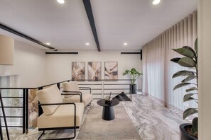 Ein modernes Wohnzimmer mit Sofa, Couchtisch und einem Kunstwerk an der Wand.