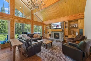 A spacious living room with a fireplace, leather sofas, and a television. - True Ski-In/Out Luxury Chalet • Hot Tub • Sauna (Big White)