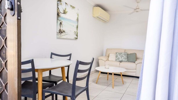 Ein Essbereich mit Tisch und Stühlen, einer Couch und einem Deckenventilator.