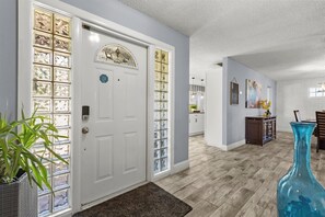 A hallway with a white door, a large blue vase, and a plant. - Cozy & Spacious 2-bedroom suite in gorgeous Orlando ~ 6 guests & close to it all (Orlando)