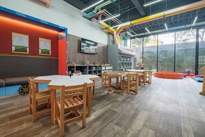 Ein modernes Interieur mit Holzmöbeln, einem Flachbildfernseher und einem Spielbereich mit Spielzeug.