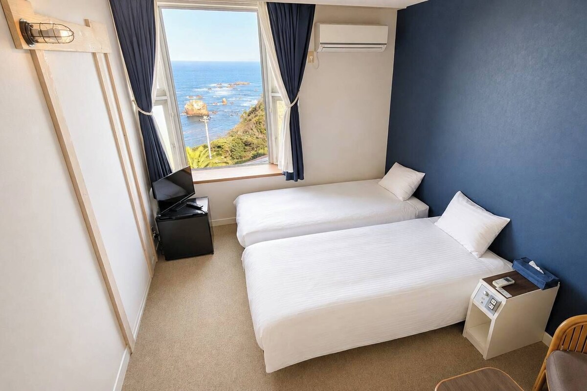 Habitación básica con 2 camas individuales, vistas al mar | Espacio para trabajar con un portátil, wifi gratis, ropa de cama
