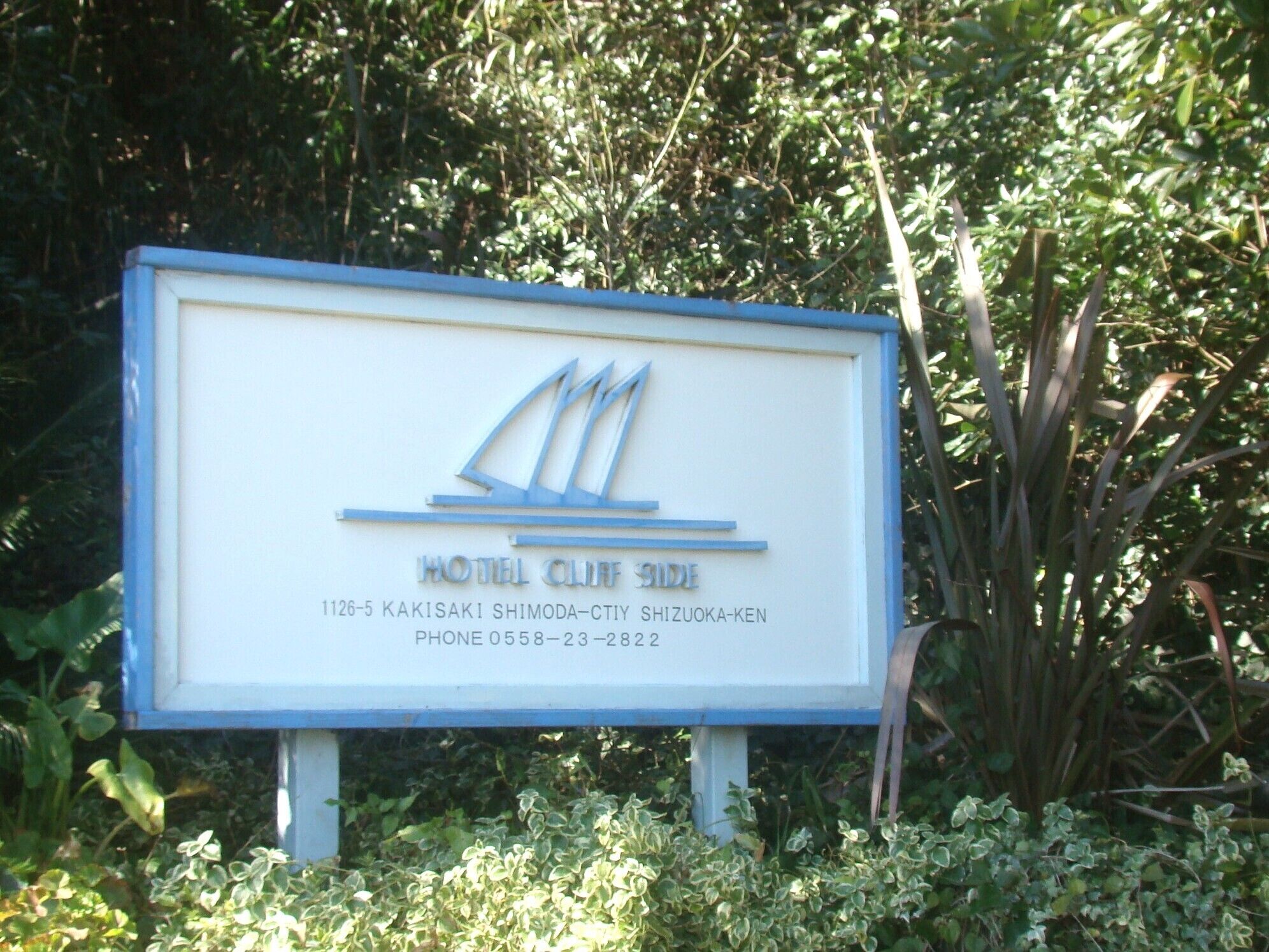 A hotel sign with a sailboat logo, indicating a nautical theme.