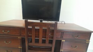 Ein Holztisch mit Schubladen und einem Fernseher darauf.
