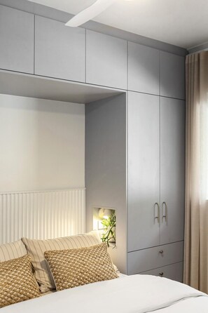 Ein Schlafzimmer mit einem Bett, einem Nachttisch, einer Lampe und einem Kleiderschrank.