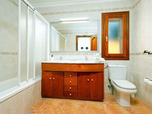 Ein Badezimmer mit einem Holzbadezimmerhocker, einer Toilette und einem Spiegel.