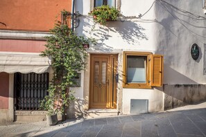 Ein Gebäude mit Holztür, Fensterläden und einem Blumentopf.