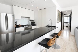 Eine moderne Küche mit einer großen Kochinsel, Edelstahlgeräten und einem minimalistischen Design.