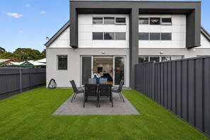 A modern two-story house with a patio area featuring a table and chairs. - The Garfield Nest — Steps From Everything (Kurralta Park)