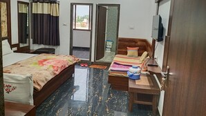 Ein Hotelzimmer mit einem Bett, einem Schreibtisch, einem Fernseher und einer Klimaanlage.