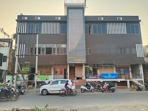 A hotel named 'Hotel Gungun' with a modern architectural design, featuring a prominent vertical element and multiple windows.