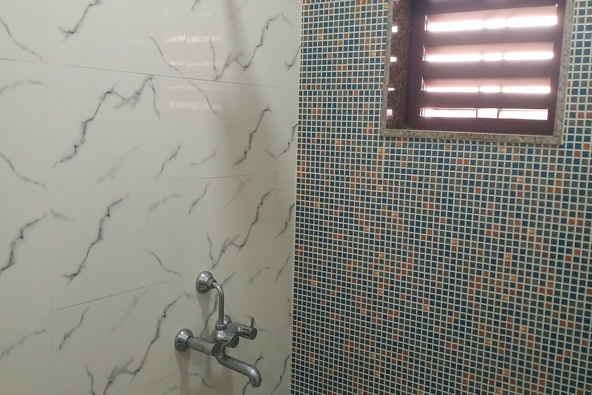 Un baño con ducha, ventana y azulejos decorativos.