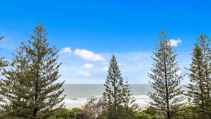 A coastal landscape with trees and a beach. - Iconic Burleigh Beachfront, 2 Bedroom Apartment (Gold Coast)