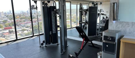 A gym with exercise equipment, a bench, and a water dispenser.