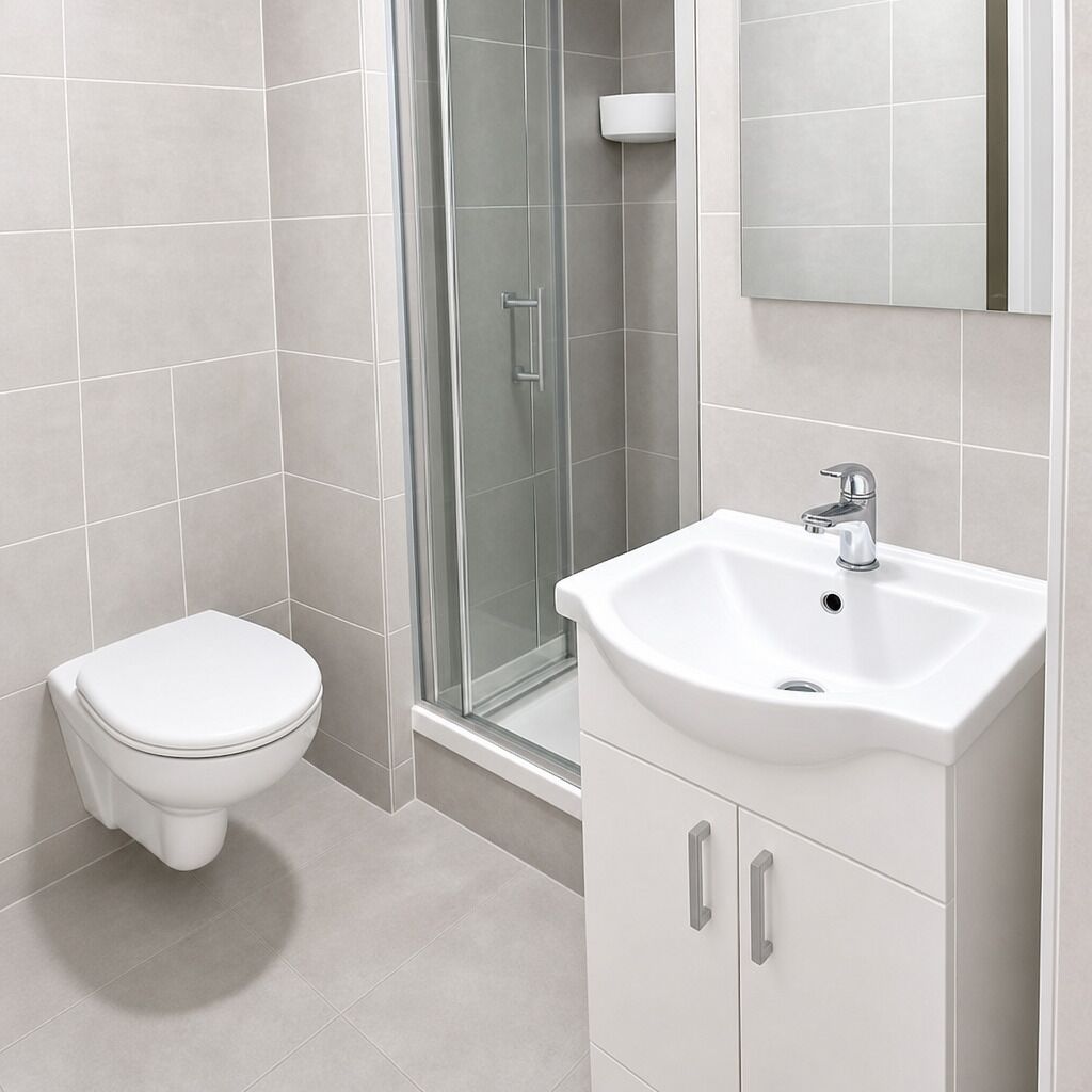 Un baño con inodoro, lavabo y cabina de ducha de vidrio.