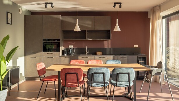 Uma cozinha moderna com área de jantar, incluindo mesa e cadeiras, e uma janela grande que proporciona luz natural.