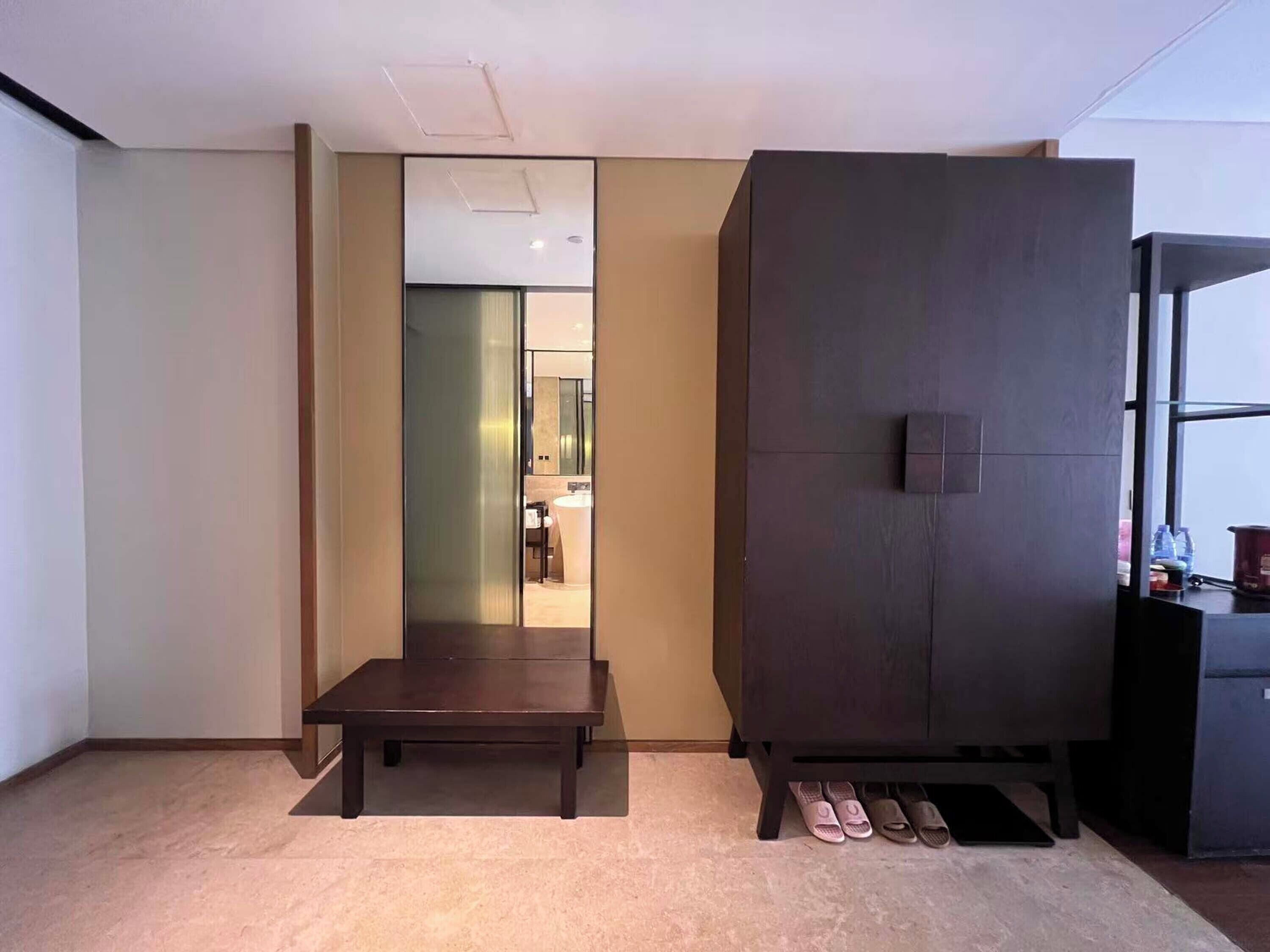 A modern room with a large wardrobe, a small table, and a mirror.