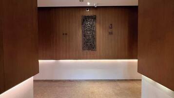 A hallway with wooden paneling, a reception desk, and a security camera.