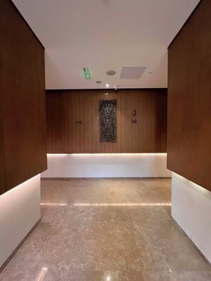 Un pasillo con paneles de madera, un mostrador de recepción y una cámara de seguridad.