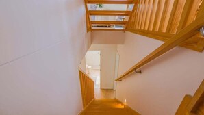 Eine Holztreppe mit Handlauf, die zu einer oberen Ebene führt.