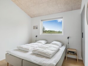 A bedroom with a large bed, a window with a view of greenery, and a bedside table with a lamp. - "Huldrik" - 900m from the sea by Interhome (Løkken)
