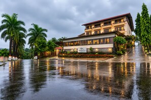 Un edificio de resort con techo rojo, varios balcones y un letrero que indica que es un resort Shantisarovar.