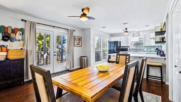 A modern kitchen with a dining area, wooden table, and chairs.