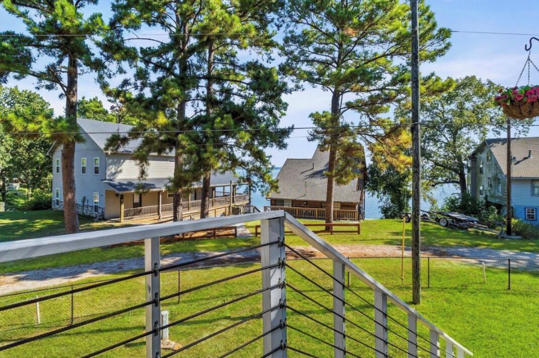 A residential area with houses, a grassy lawn, and a dock extending into a body of water.
