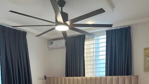 A bedroom with a bed, a nightstand, a ceiling fan, and a window with curtains. - BGG Havens (Accra)